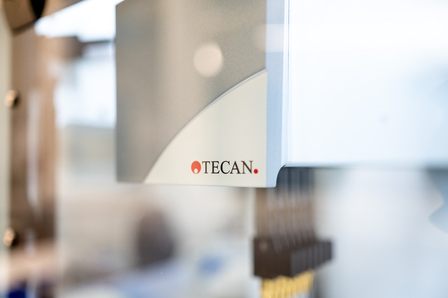 A close up of a Tecan liquid handler, focused on the Tecan logo